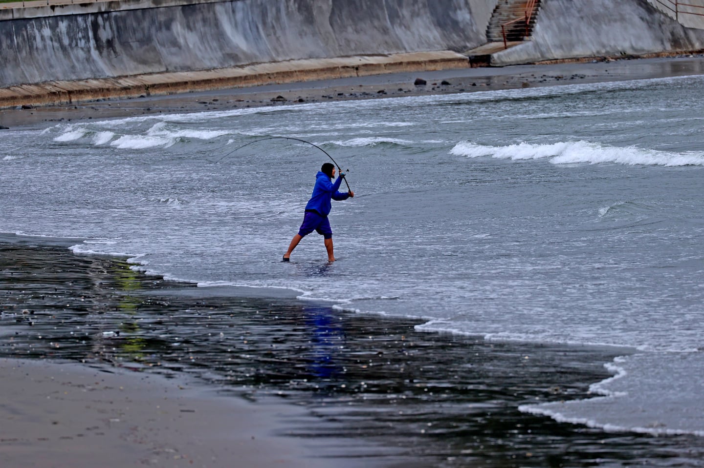 Sidney Cocchia, from Lynn, fishes the high surf on the Swampscott shoreline. A high surf advisory continues today along the New England coast, from Portland, Maine, to Rhode Island.