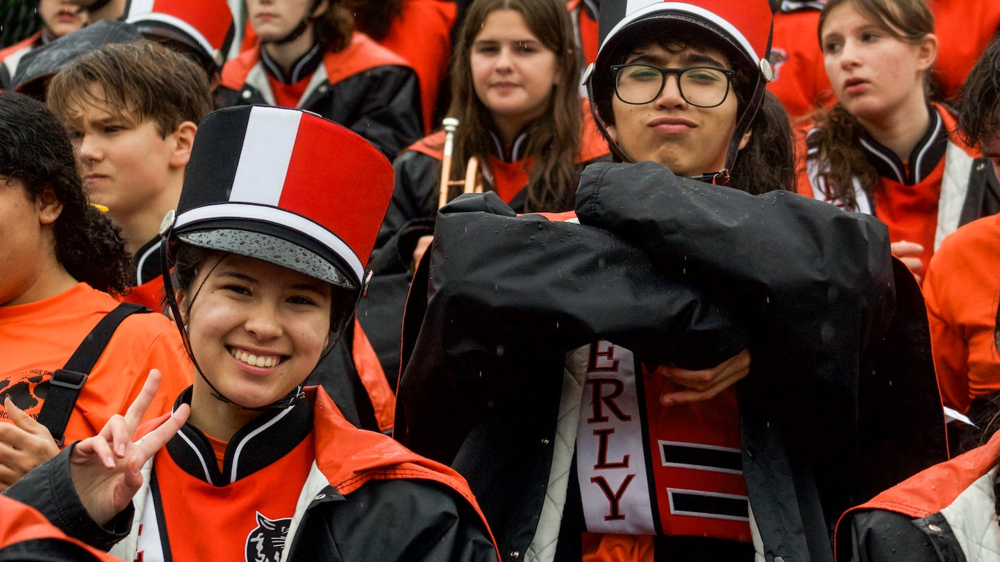 Neither the rain nor the score could dampen the spirits of Genevieve Chan (left) and Brandon Hiduchick from the Beverly High School marching band during the football team's 40-14 loss to visiting North Andover on Sept. 21, 2024.