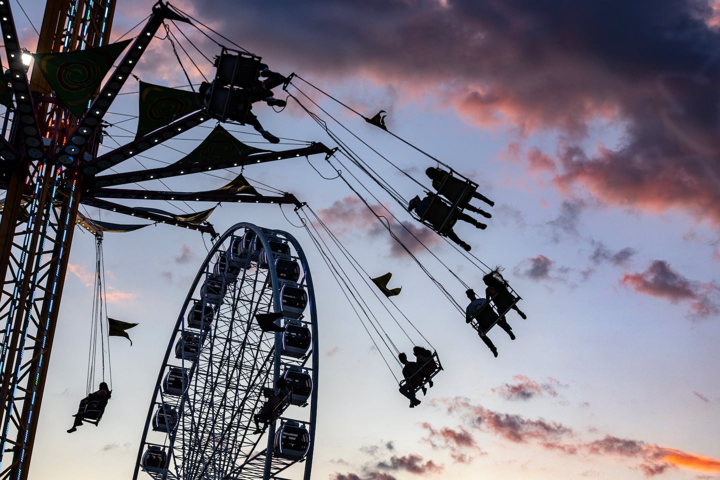 At sunset at The Big E in West Springfield, fairgoers enjoy the scene from the Super Wheel and other rides.