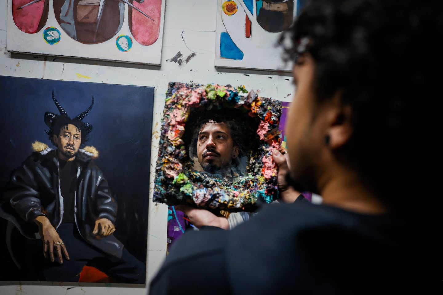 Jameel Radcliffe poses for a portrait in his studio at Boston Center for the Arts. The work hanging from his walls is from his series "Kids from the Stars."