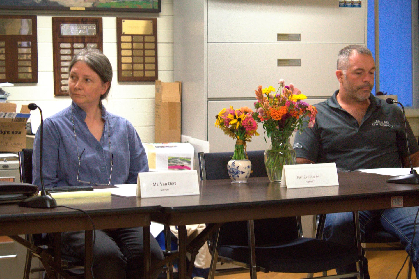 On Sept. 17, Pawlet Select Board members Jessica Van Oort and Rich Hulett sat next to the seat and flowers remembering slain Select Board member Brian Crossman Sr., who along with his wife and son were found shot to death in their home.