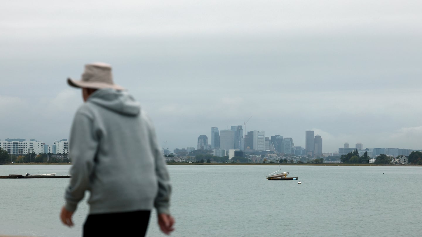 A man walks along Wollaston Beach in Quincy Thursday morning. New England will see decreasing clouds today.