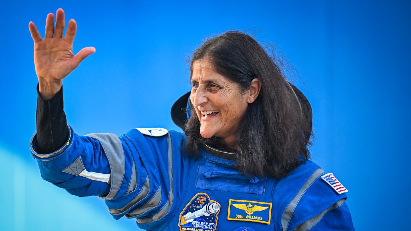 NASA astronauts Suni Williams waves as she prepares to depart the Neil A. Armstrong Operations and Checkout Building for Launch Complex 41 to board the Boeing CST-100 Starliner spacecraft in June.