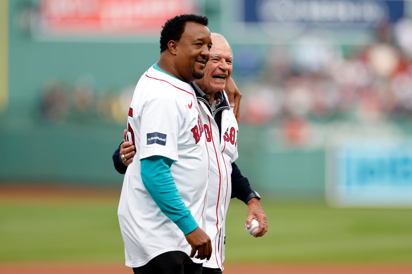 Longtime radio announcer Joe Castiglione (right) and former Red Sox pitcher Pedro Martinez walk off the field after a ceremony honoring Castiglione’s 42-year career before the final game of the season at Fenway Park.