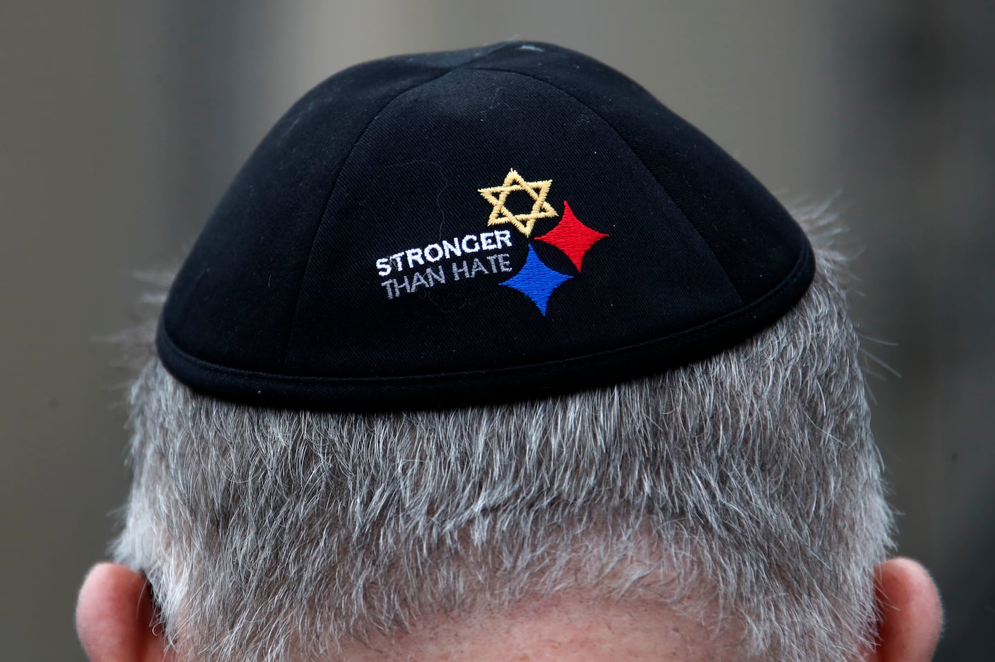 A man wearing a "Stronger Than Hate" yarmulke outside the Tree of Life synagogue in Pittsburgh, where 11 Jews were massacred in 2018.