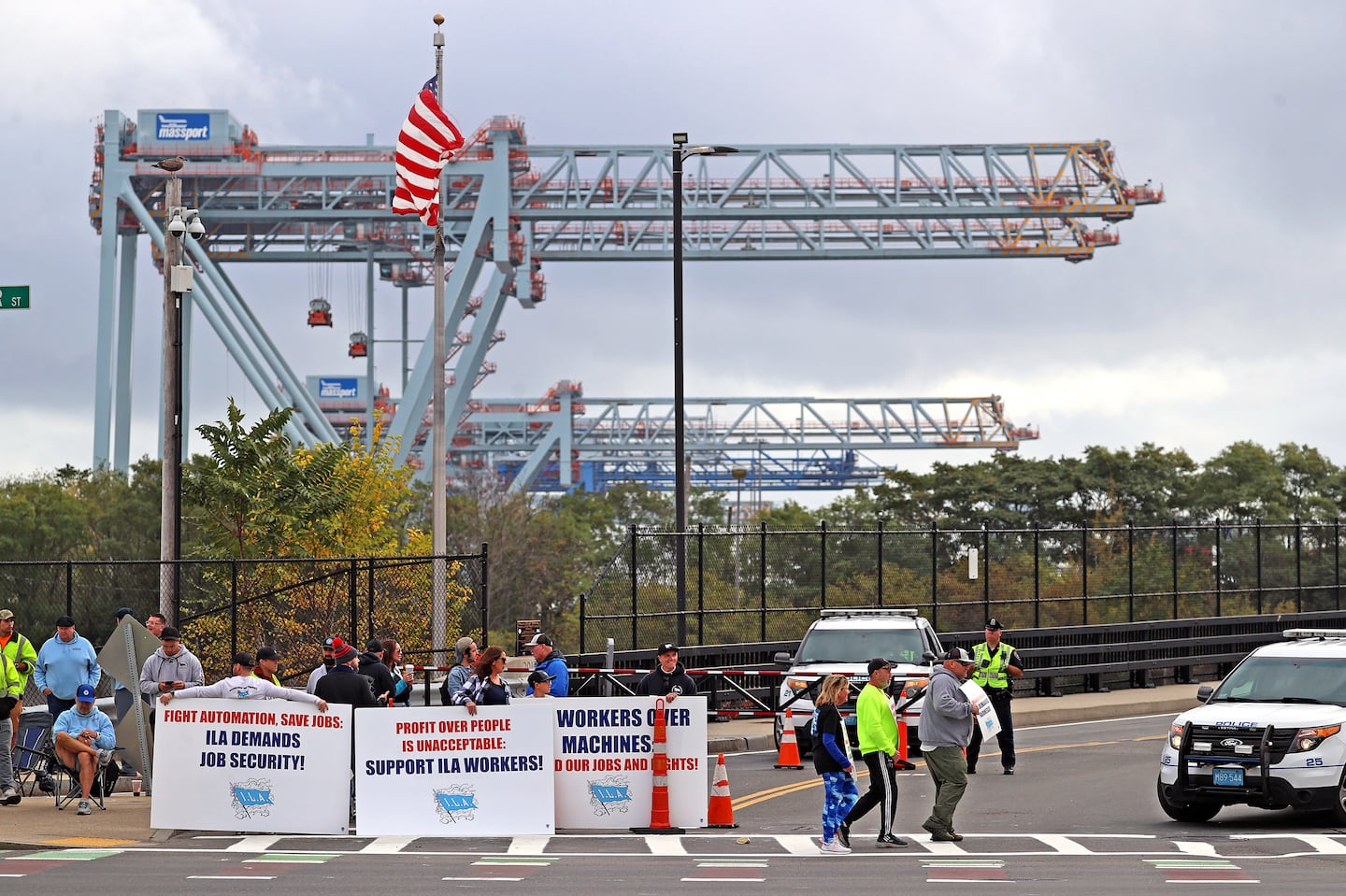 Dockworkers on strike outside Conley Terminal in South Boston on Tuesday morning. The shutdown of ports up and down the East Coast could take a significant toll on local companies and the broader economy.