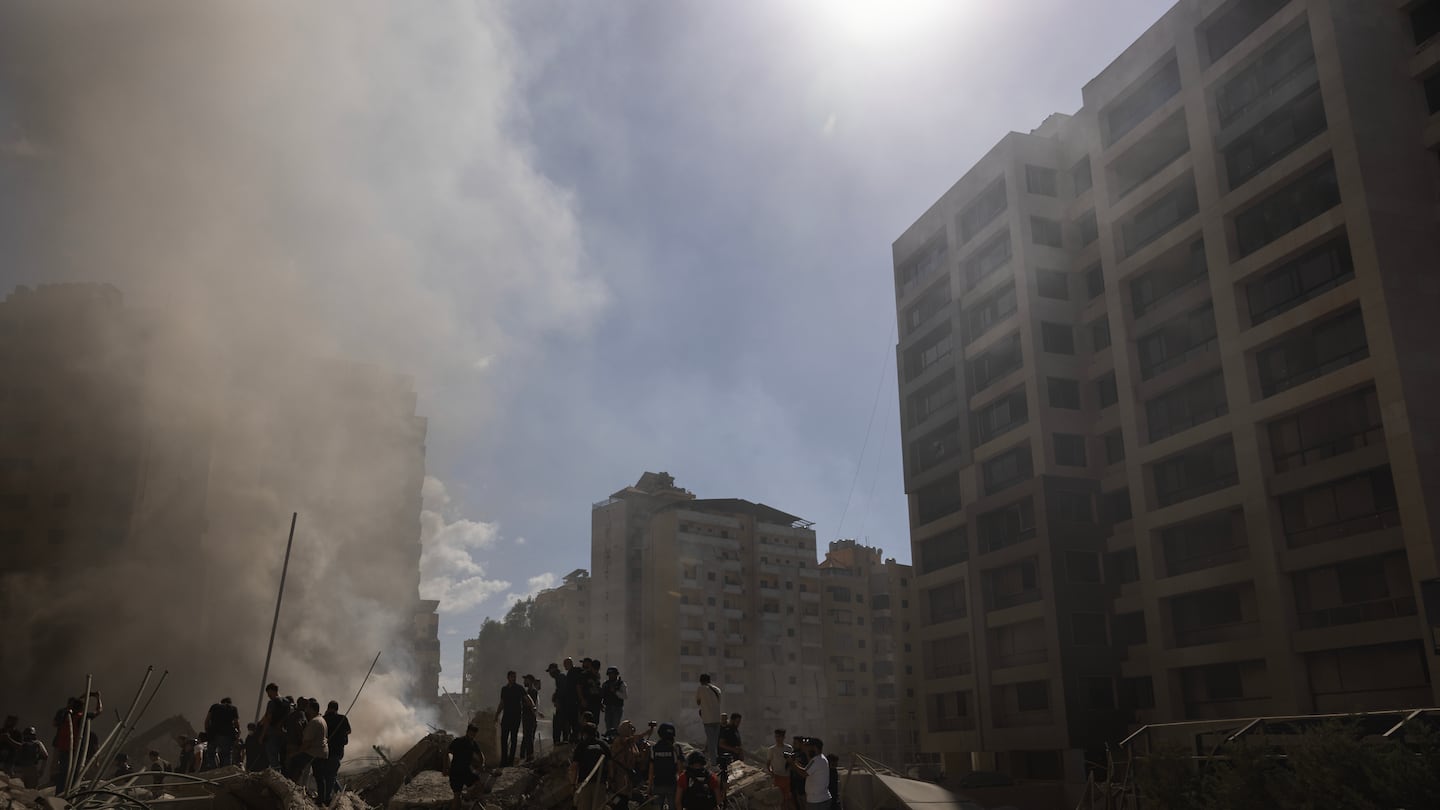 Smoke rises from a building destroyed by an Israeli airstrike as journalists and local residents visit during a press tour on Wednesday in Beirut, Lebanon.