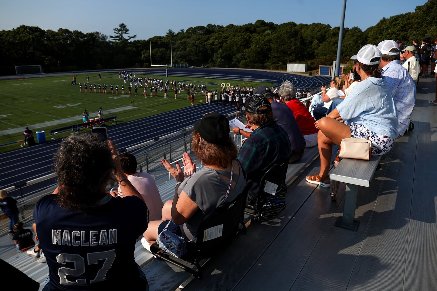 Plymouth North High School fans cheered as the team makes its entrance onto the playing field last month. The town moved outdoor night activities to the daytime due to risk of mosquito-borne EEE.