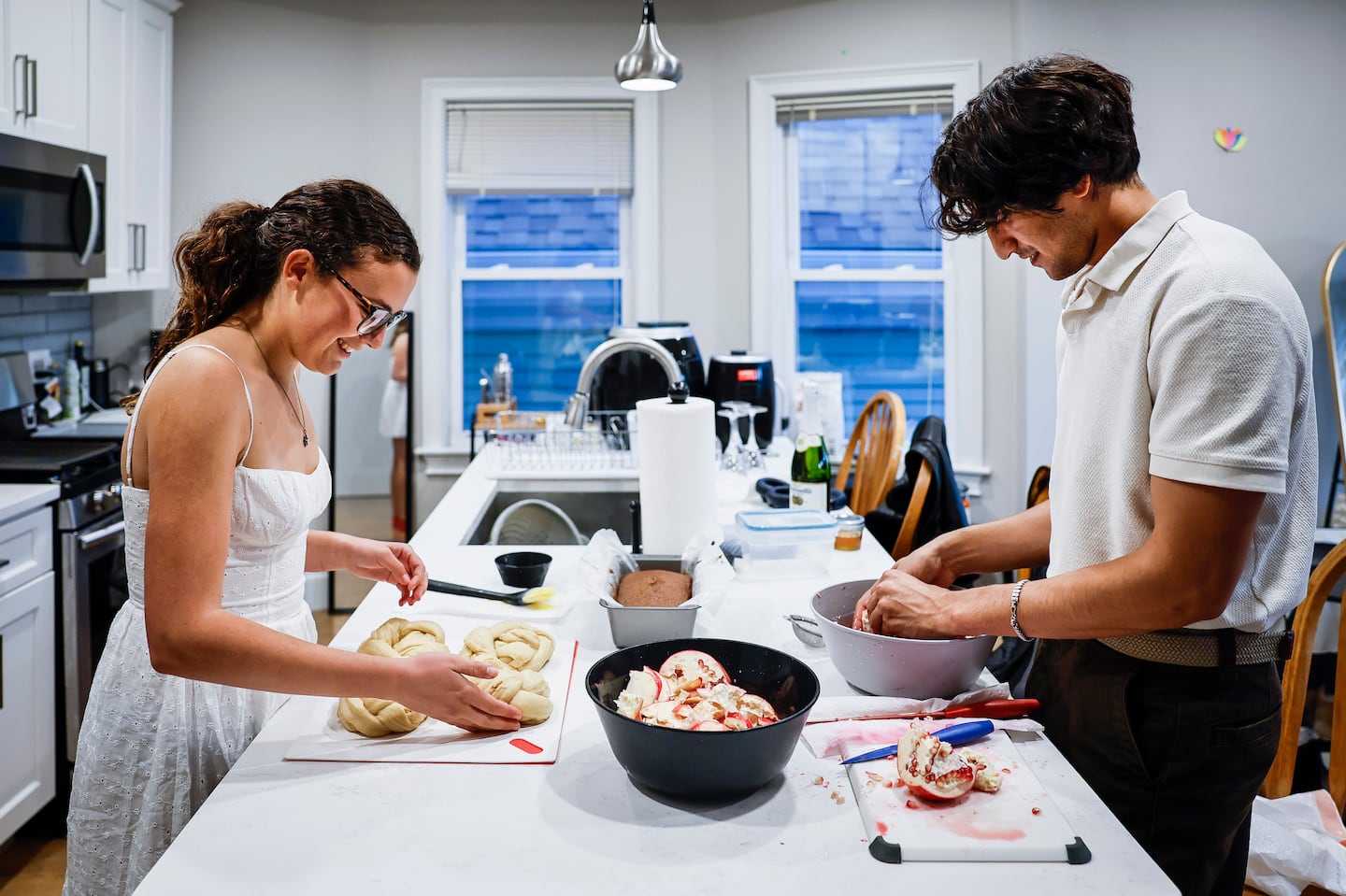 Devon White, left, prepares challah bread while Ethan Handel cleans pomegranate seeds for a dinner in celebration of Rosh Hashana.