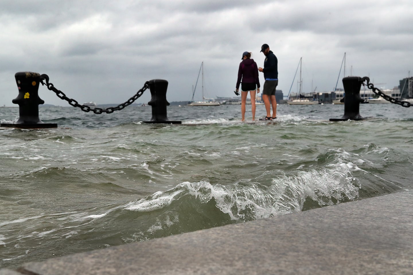 A very high tide, known as a king tide, flooded sections of Long Wharf in Boston in September. The city is working to build dozens of flood protection projects as sea levels rise, increasing the risk of floods during storms.