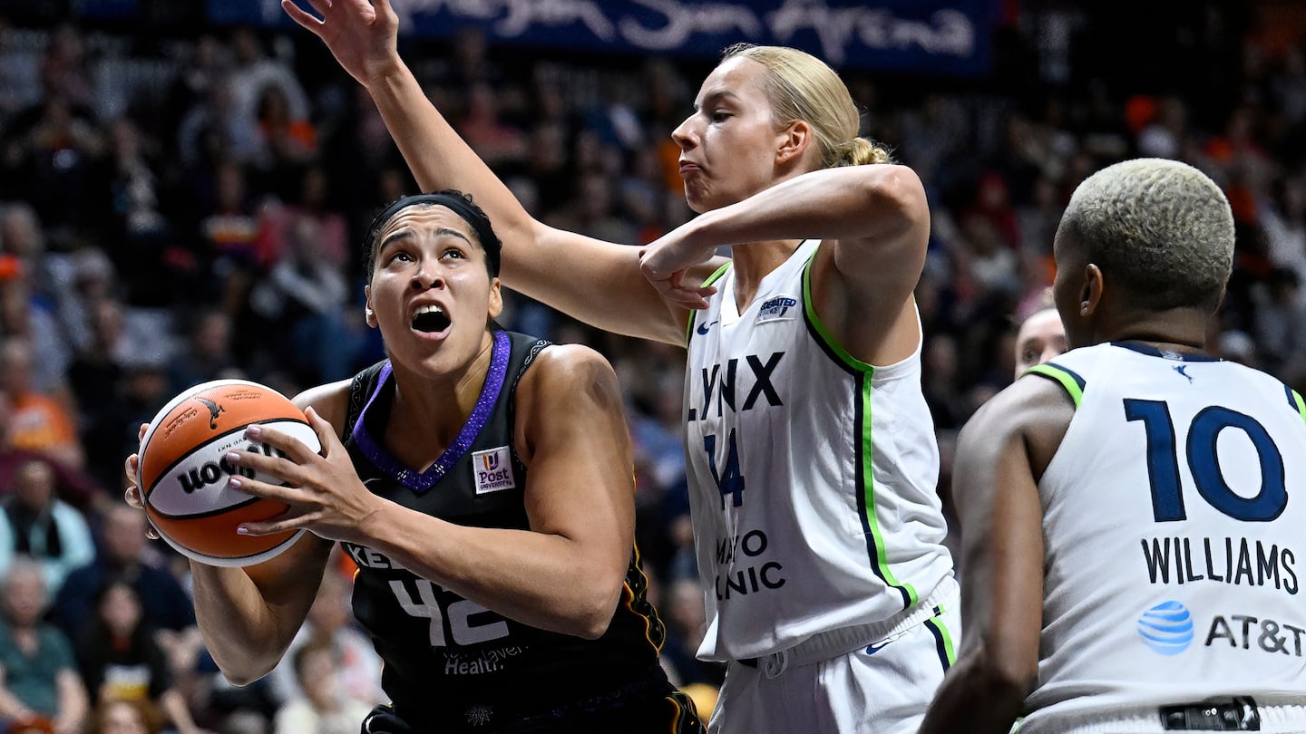 Brionna Jones (left) looks to shoot as Lynx forward Dorka Juhasz defends during the second half. Jones scored 21 points, but it wasn't enough to lift Connecticut over Minnesota.