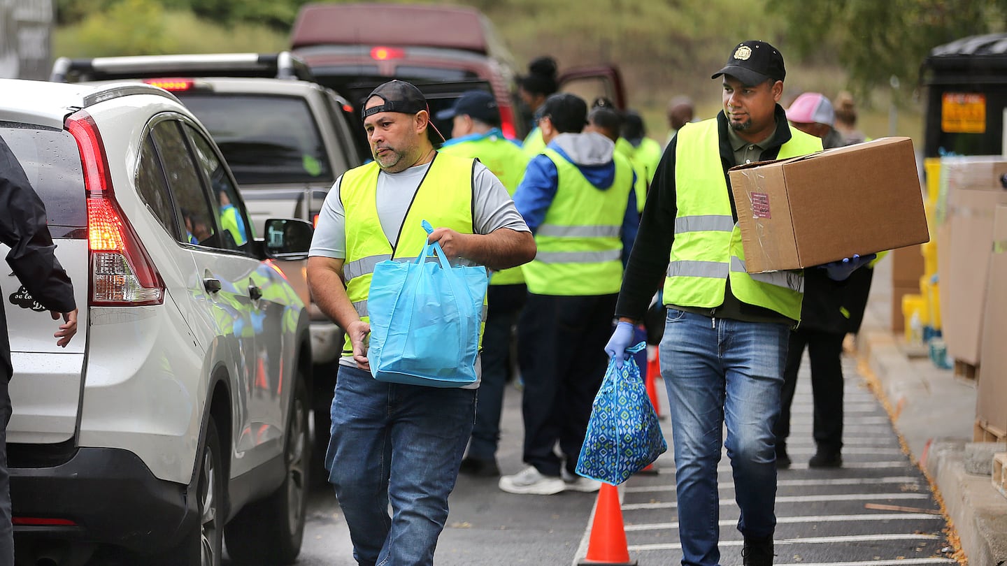 Hundreds of people lined up in their vehicles on Sept. 21 in Pawtucket, R.I., some waiting in line for more than two hours to get food and household items during a "share market" organized by the Elisha Project, a Pawtucket-based nonprofit.