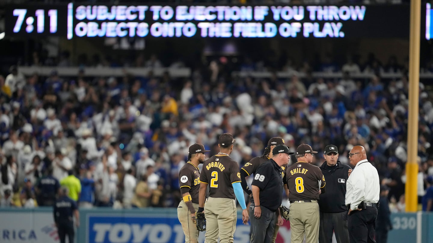 San Diego Padres manager Mike Shildt (8) and players talk to umpires after items were thrown on the field by fans during the seventh inning.