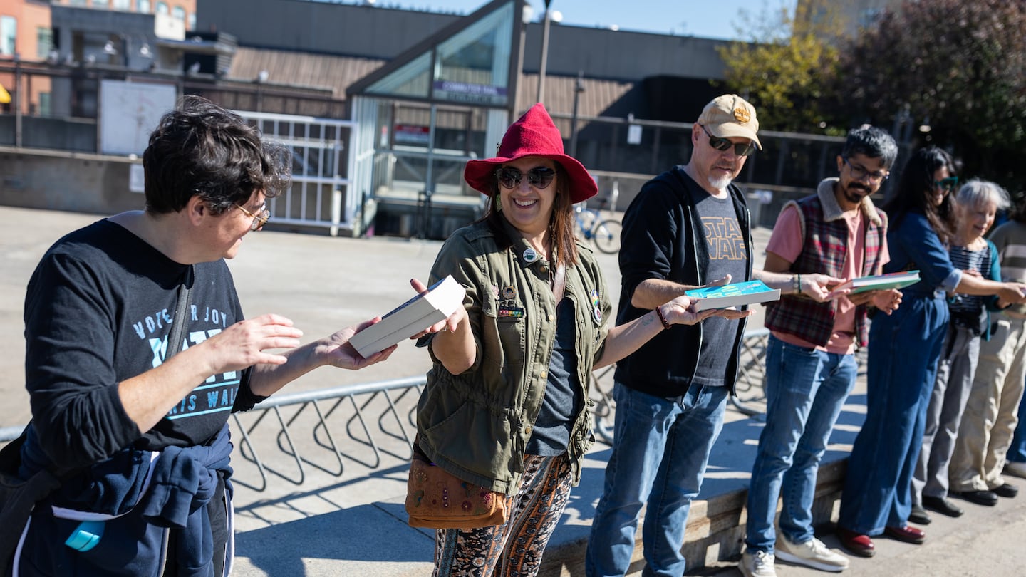 Mali Wilson of Woburn took part in a human chain to help Porter Square Books move books from its old location to a new storefront a few blocks away on Massachusetts Avenue in Cambridge.