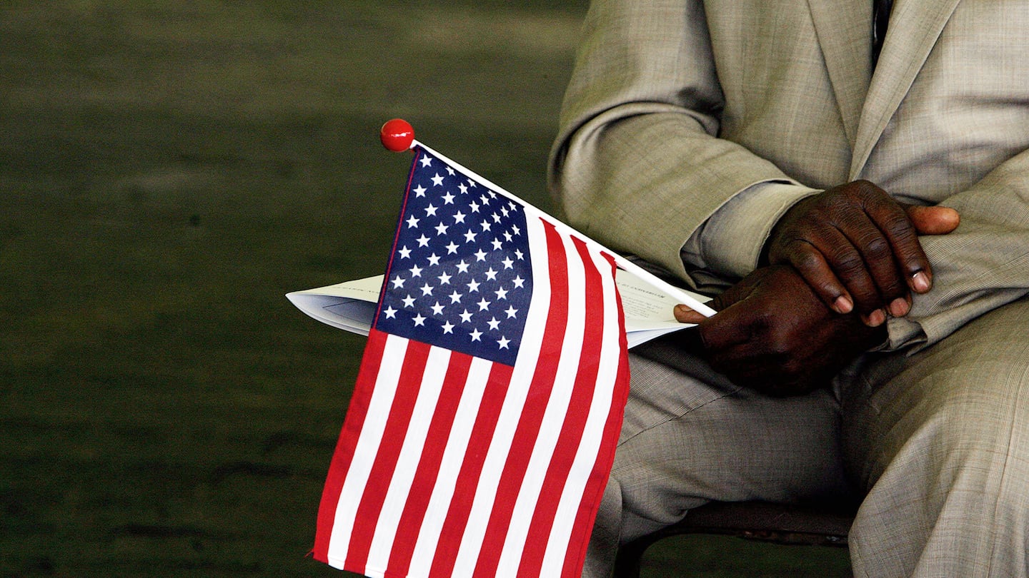 Jeneba Kanu, originally from Sierra Leone, held an American flag while waiting to become a US citizen during a naturalization ceremony at George Washington's Mount Vernon in Alexandria, Va., in May 2006.