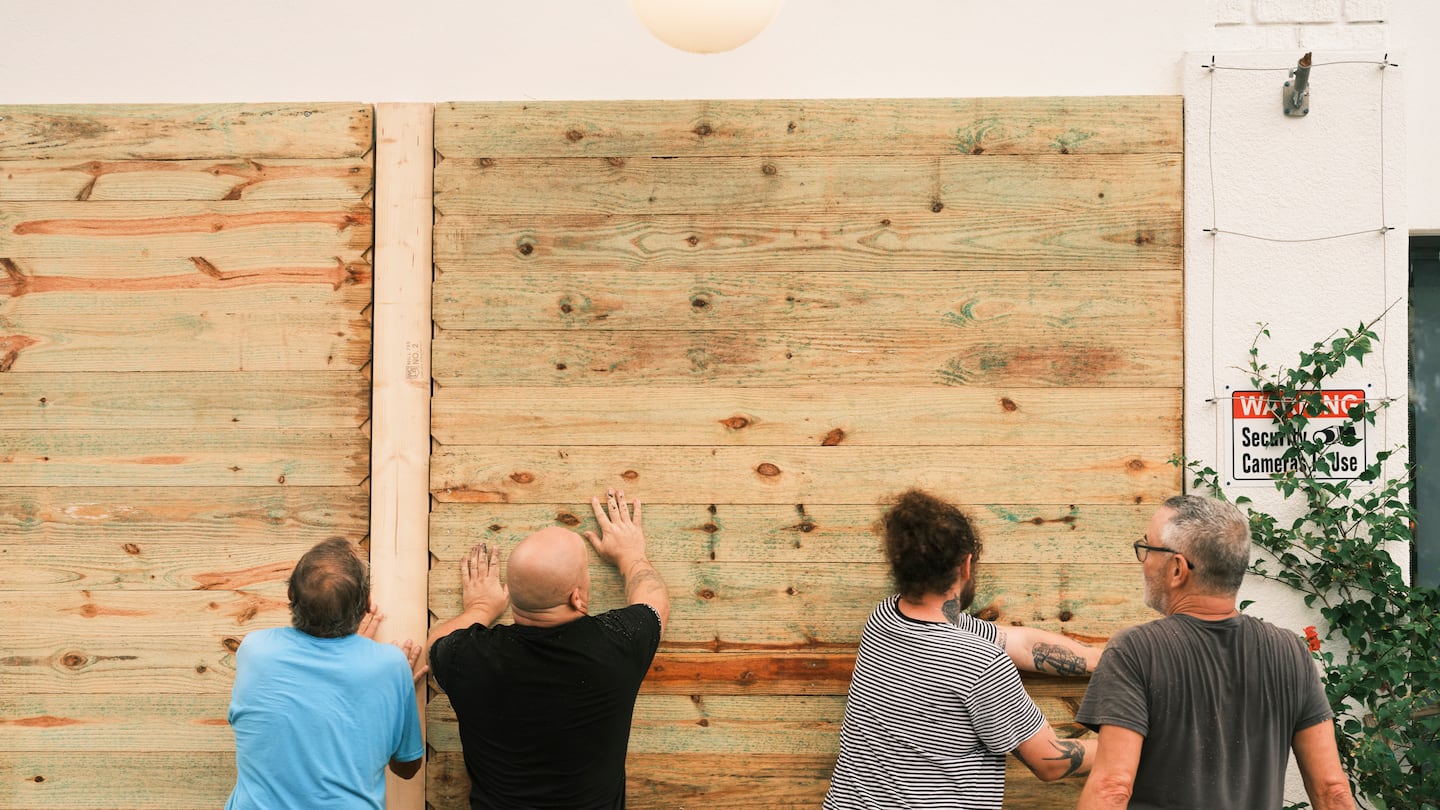 Residents install wood panels to protect the windows in St. Petersburg, Fla., on Oct. 7.