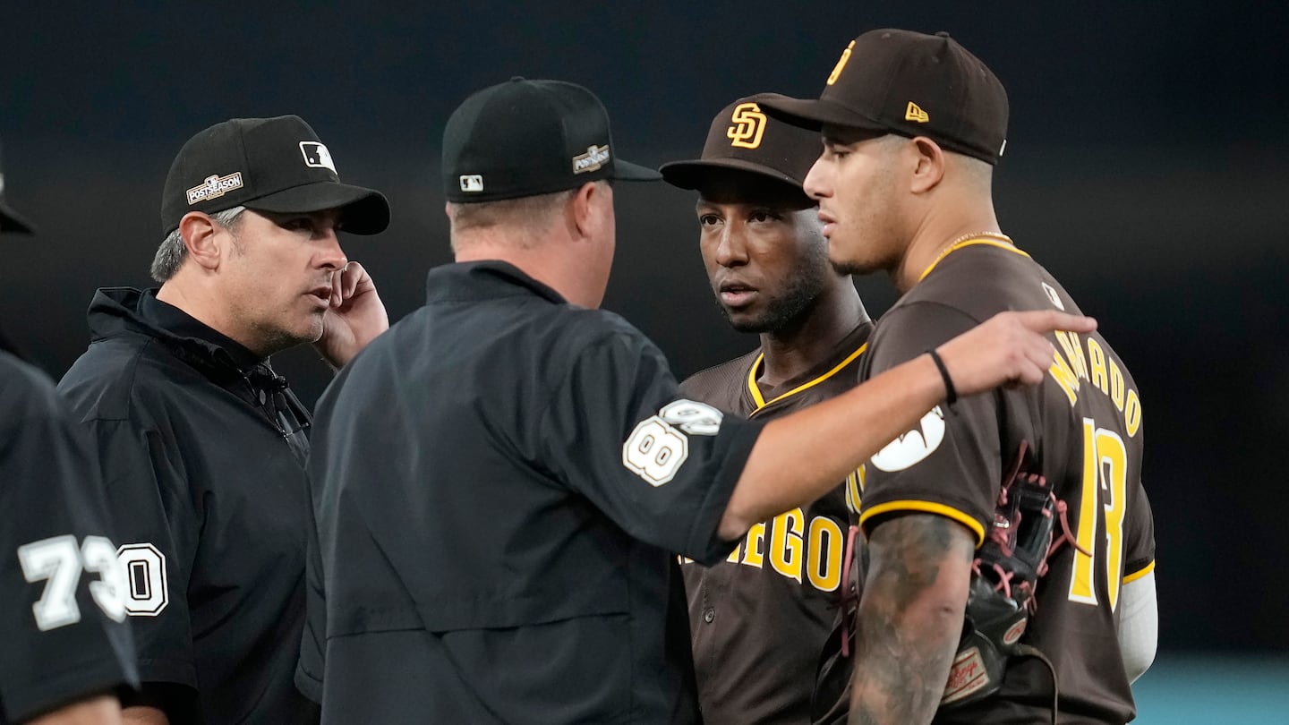 Padres left fielder Jurickson Profar (second from right) and third baseman Manny Machado talk to the umpires during Sunday night's hot-tempered playoff game at Dodger Stadium.