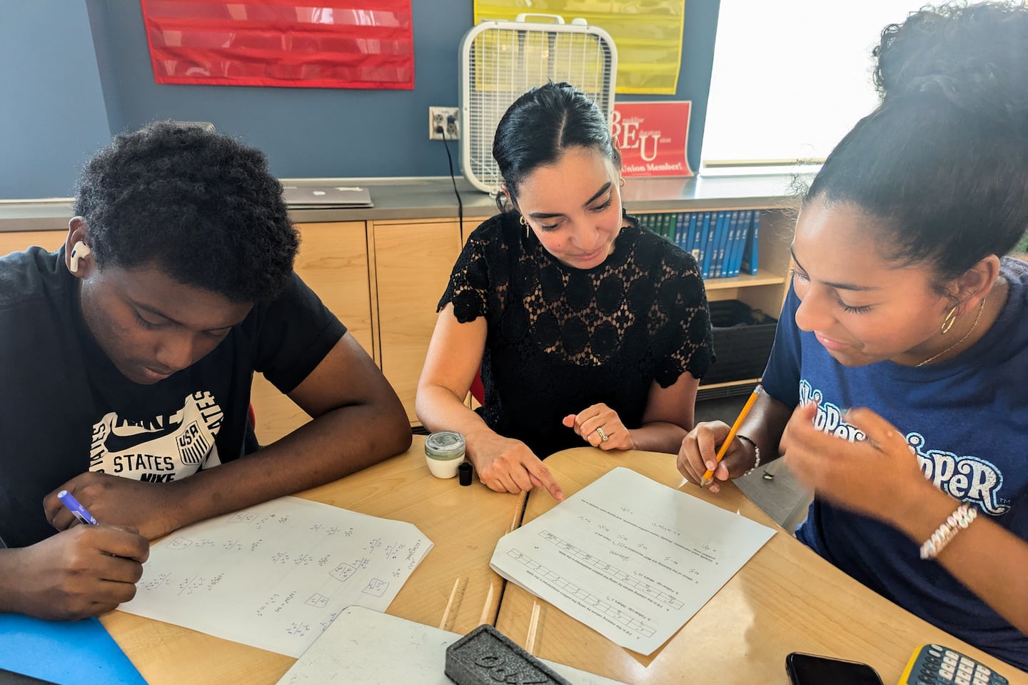 Lisa Rodriguez, who teaches Algebra II and Pre-Calculus Honors and is co-director of the Calculus Project at Brookline High, photographed with students. She said the program has enabled the school to create a team of math teachers, counselors, and volunteers who students can rely on for support.