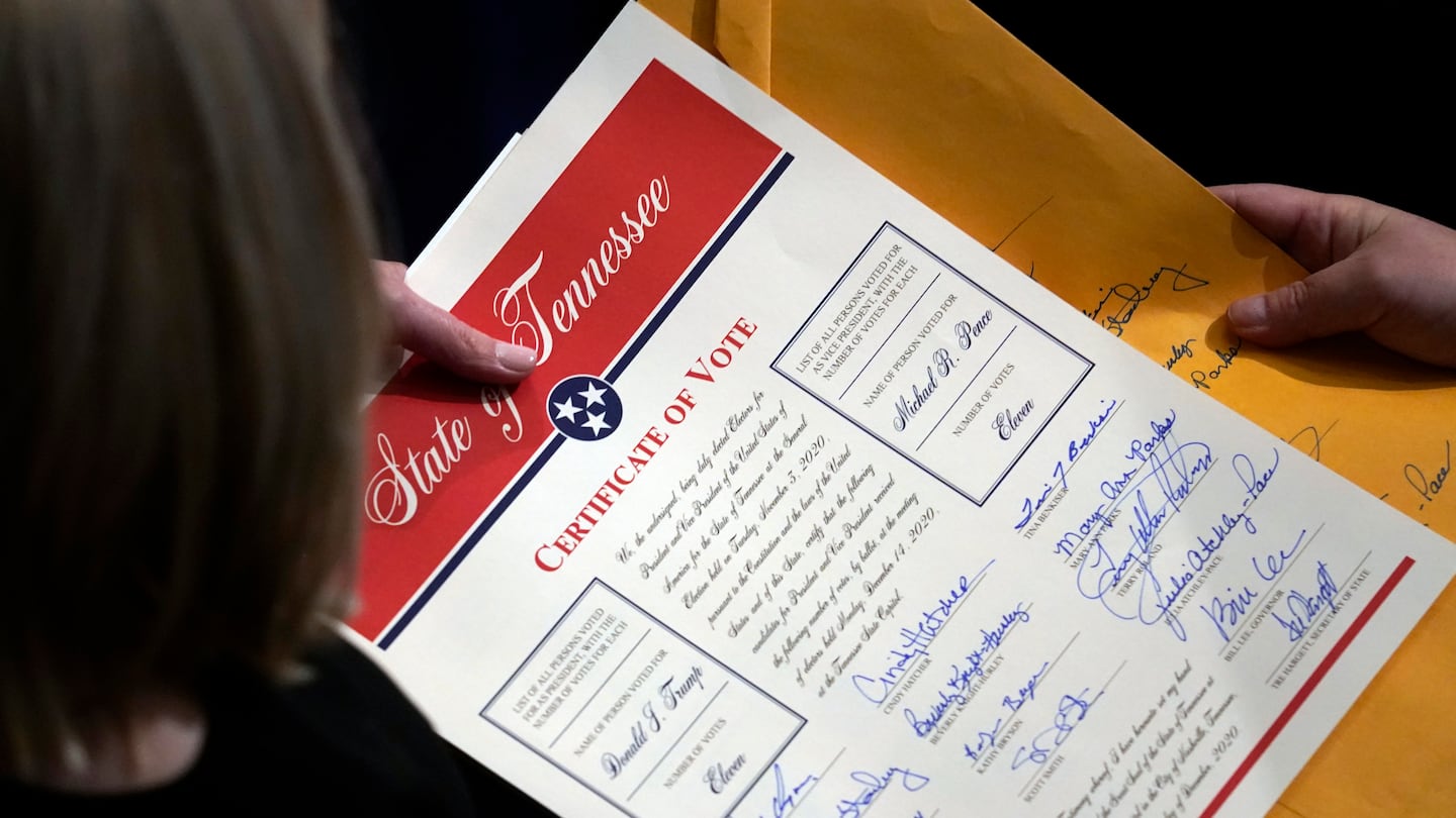 Staff members hold the certification of Electoral College votes from Tennessee during a joint session of the House and Senate to confirm Electoral College votes at the Capitol, early Jan 7, 2021, in Washington.