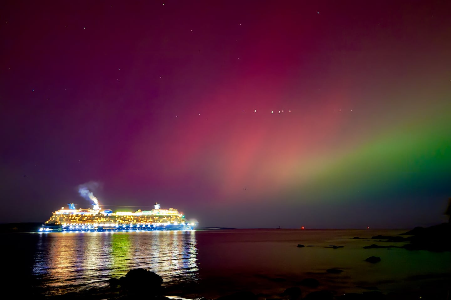 The aurora borealis shines over a cruise ship passing through Portland, Maine.