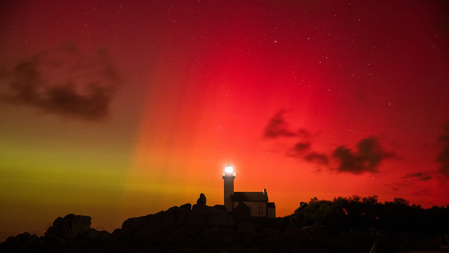 An aurora borealis tints the sky red and green above the Pontusval lighthouse in Brignogan, France, on Thursday.