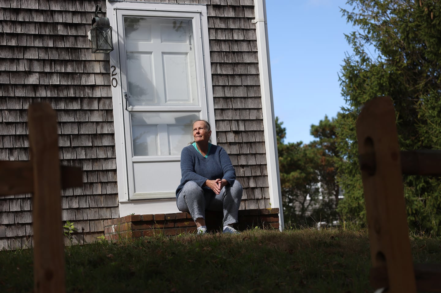 Joanne Skokan posed for a portrait on the front steps of her Nantucket home on Toms Way. After discovering their wells were contaminated with PFAS, Skokan joined her neighbors in a class action lawsuit against the companies that manufactured the chemicals.