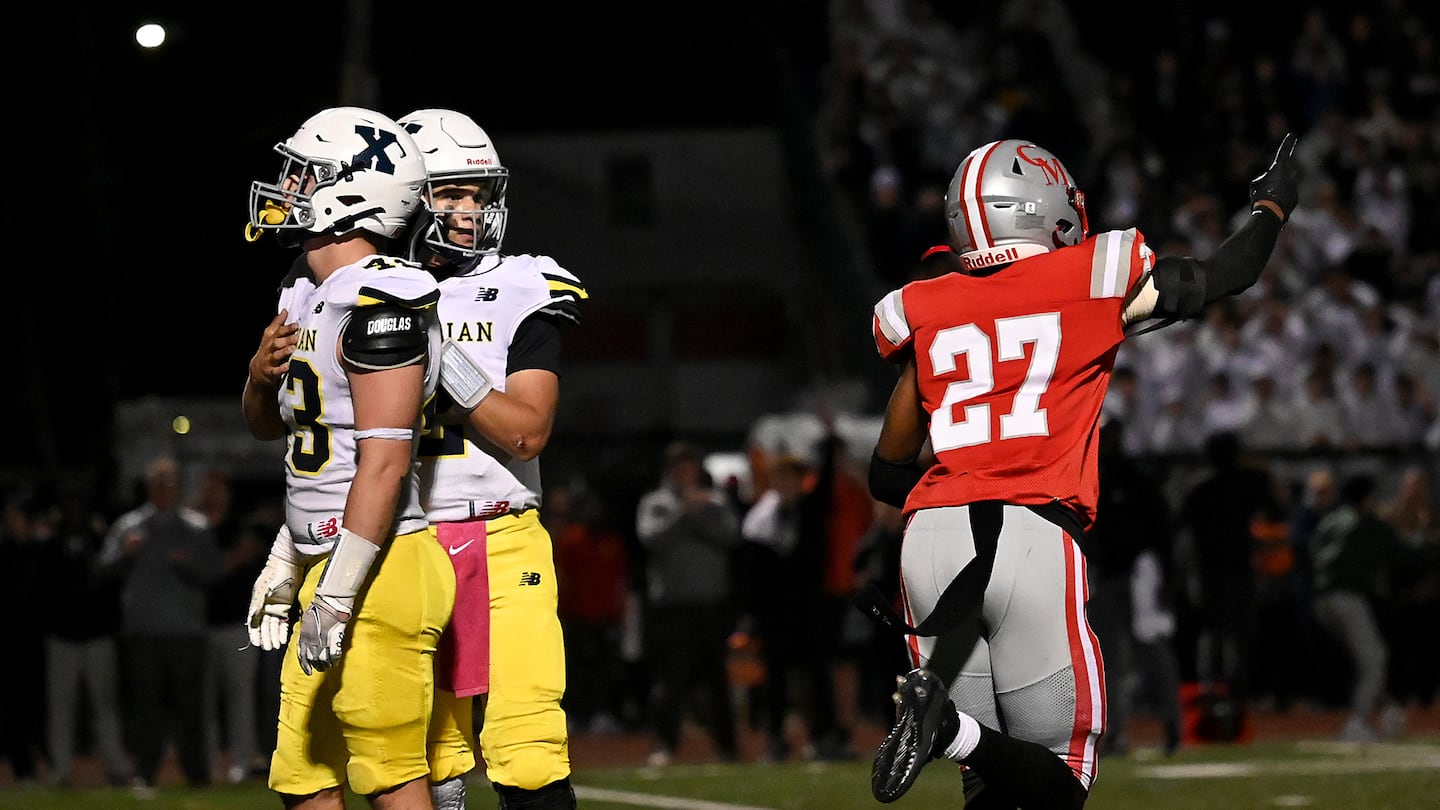 Catholic Memorial's Jackson Tucker (right) celebrates as Xaverian holder Will Wood consoles kicker Luke Bell (left) after he missed a potential game-tying kick with just over a minute remaining.