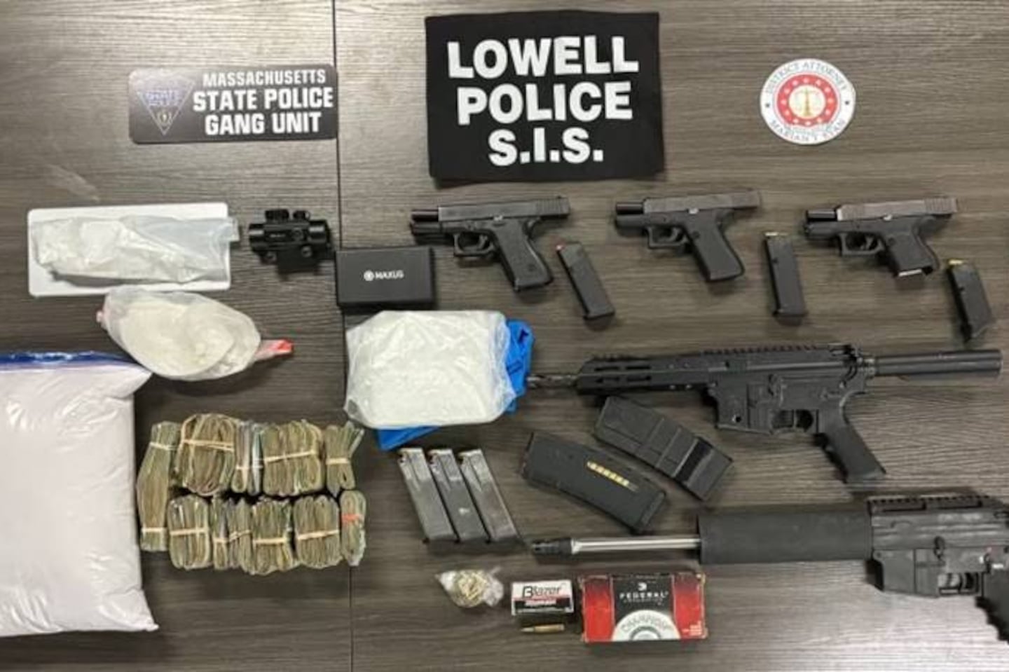 Approximately 400 grams of cocaine, over $51,000 in cash, three firearms, two AR-style rifles, ammunition in various calibers, multiple large capacity magazines, and over 900 grams of cocaine were seized from two homes in Lowell.