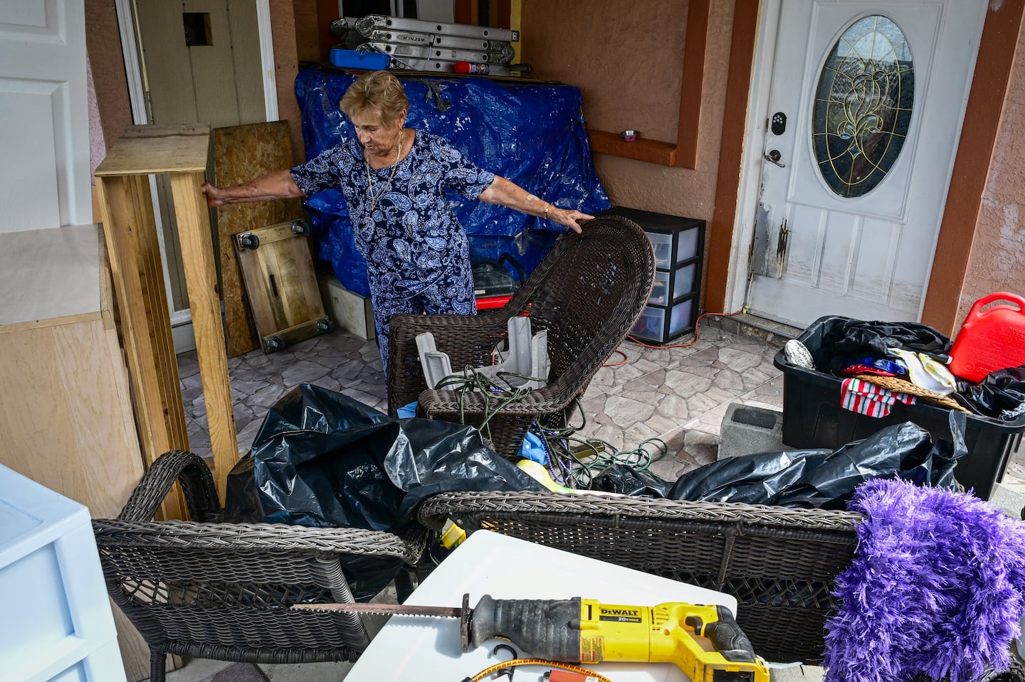 A woman tidies up in Tampa, Florida, as people remove debris and clean their homes after flooding caused by Hurricane Milton on October 11, 2024.