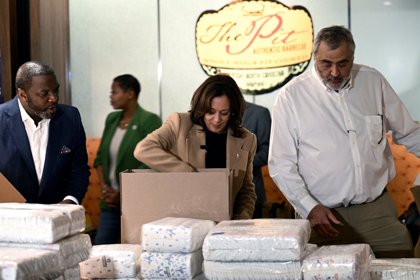 US Vice President and Democratic presidential candidate Kamala Harris (C) helps pack supplies for those affected by Hurricane Helene during a campaign stop at The Pit Authentic Barbecue restaurant in Raleigh, North Carolina, on October 12, 2024.