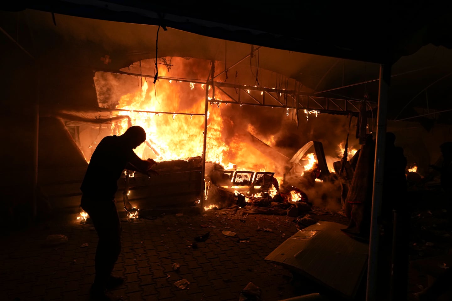 Palestinians react to a fire after an Israeli strike hit a tent area in the courtyard of Al Aqsa Martyrs hospital in Deir al Balah, Gaza Strip, on Oct. 14.