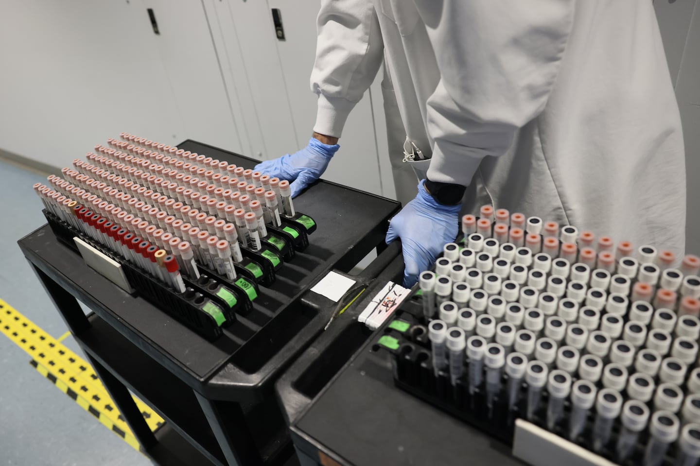 A Broad Institute employee wheeled a cart full of COVID-19 tests for processing at the Broad Institute in December 2021. At the time, the Broad Institute processed thousands of COVID-19 tests a day and then scrutinized as many as 5,000 per week for signs of worrisome variants.