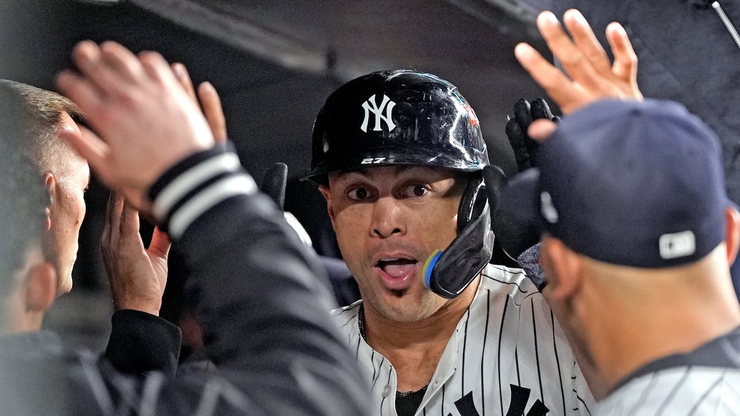 Giancarlo Stanton celebrates in the dugout after hitting a monster home run in the seventh inning Monday.