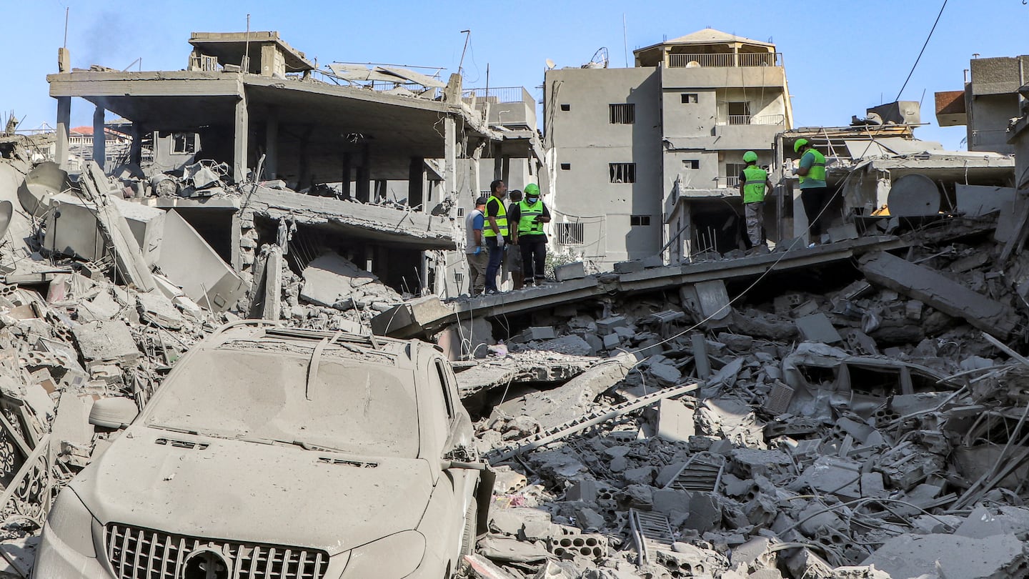 Civil defense members search for survivors through the rubble of a destroyed building at the site of an overnight Israeli air strike on the village of Qana in southern Lebanon.