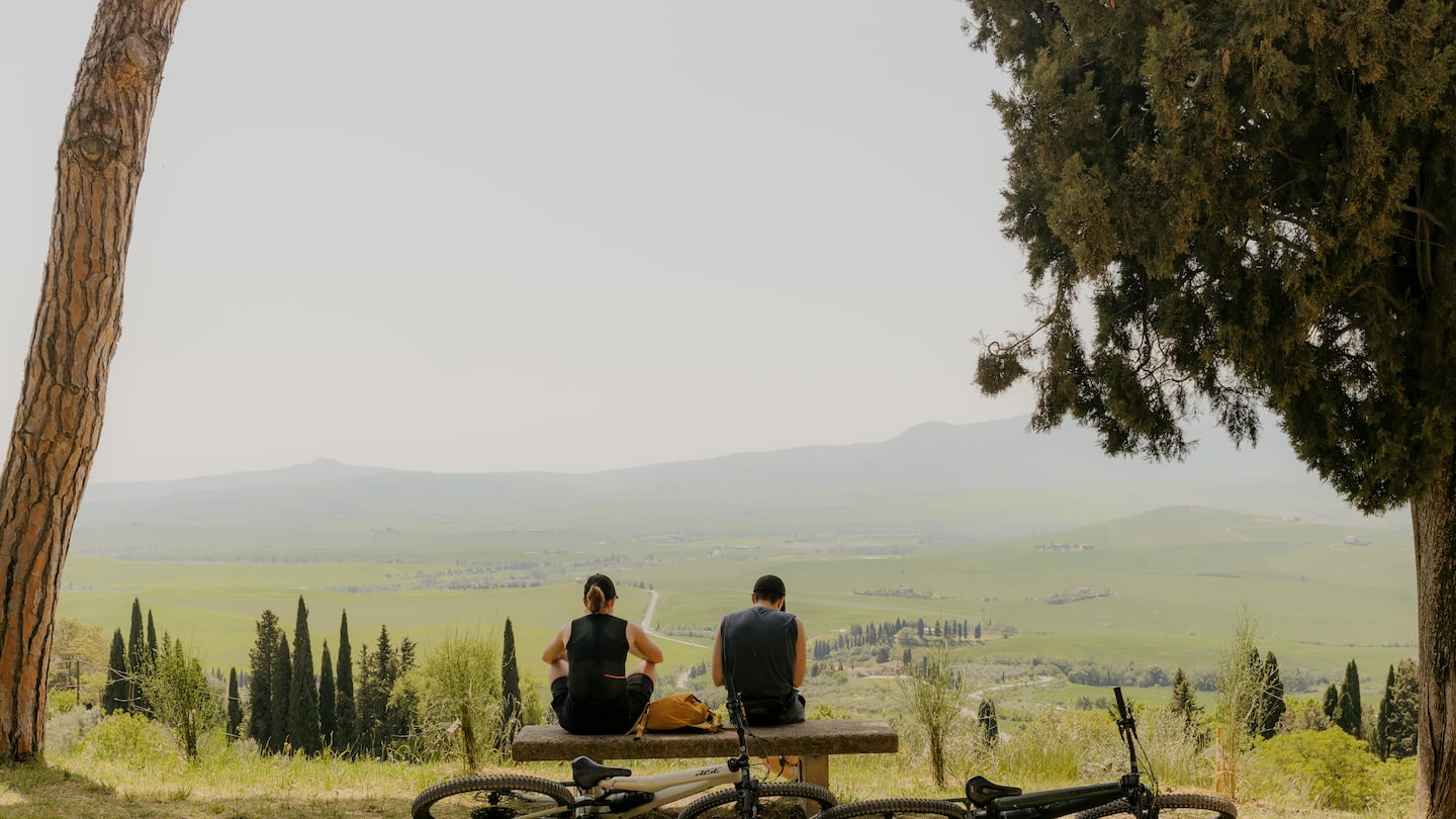 Cyclists take a break at a bench in Pienza, Italy.