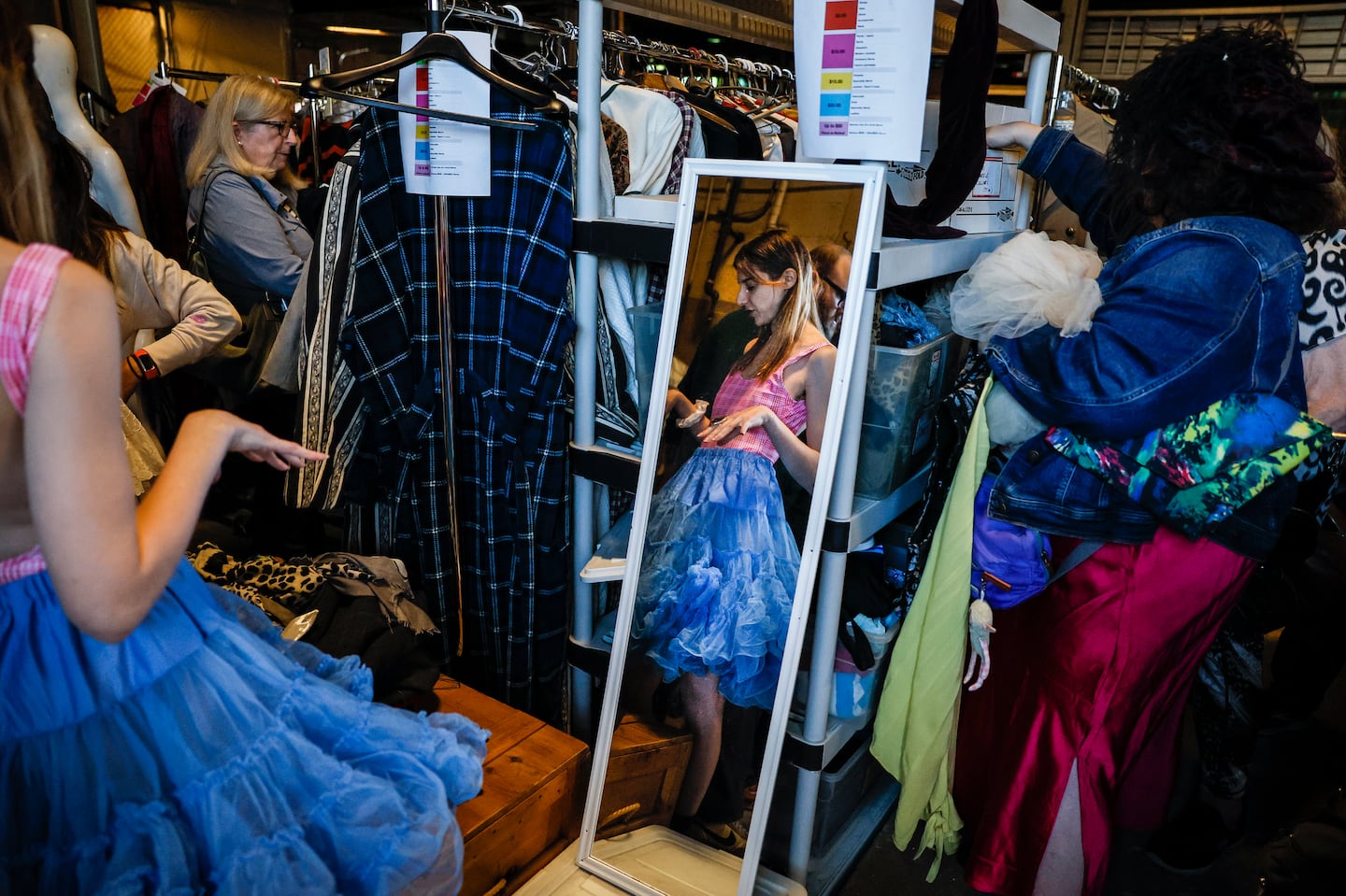 People tried on clothes and costumes at the American Repertory Theater's costume sale Friday. The sale continues Saturday and next weekend.