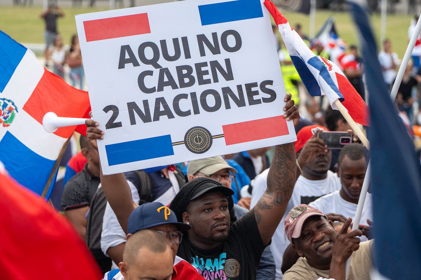 A man holds a banner that reads in Spanish 'Two nations don't fit here' during an anti-Haitian migration protest in Santo Domingo on Oct. 5.