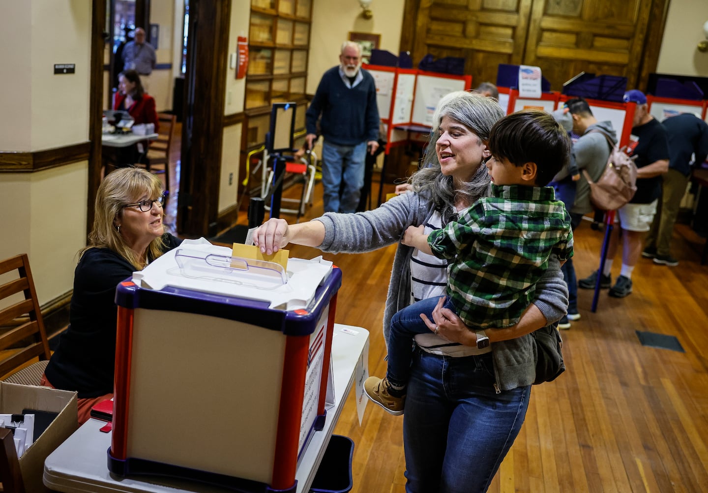 Brooke Glass voted while holding her 4-year-old son Asher during early voting at Needham Town Hall for the Nov. 5 general election.