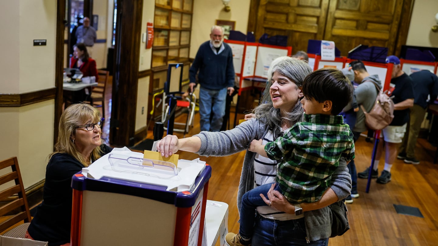 Brooke Glass voted while holding her 4-year-old son Asher during early voting at Needham Town Hall for the Nov. 5 general election.