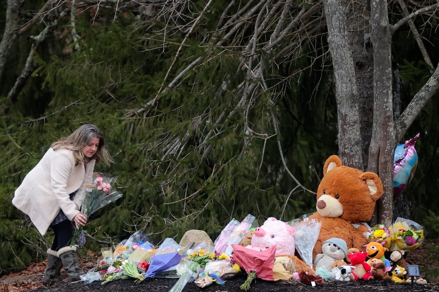 A woman left flowers at a makeshift memorial in front of the home of Lindsay Clancy, who fatally strangled three children in January 2023.