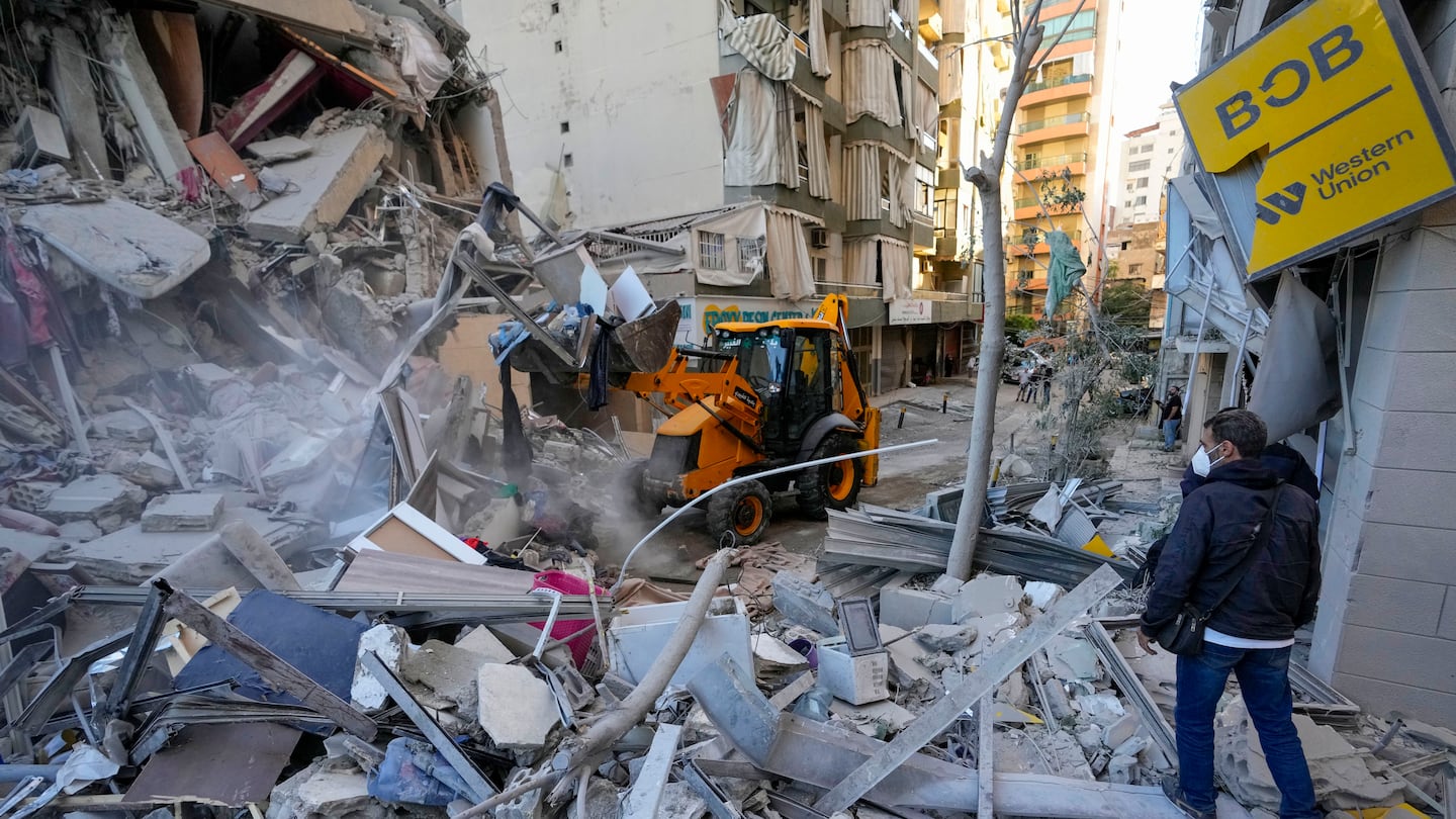 Rescue workers use a bulldozer to remove rubble of destroyed buildings at the site of an Israeli airstrike on Sunday night that hit several branches of the Hezbollah-run al-Qard al-Hassan in Beirut's southern suburb, Lebanon, on Oct. 21.