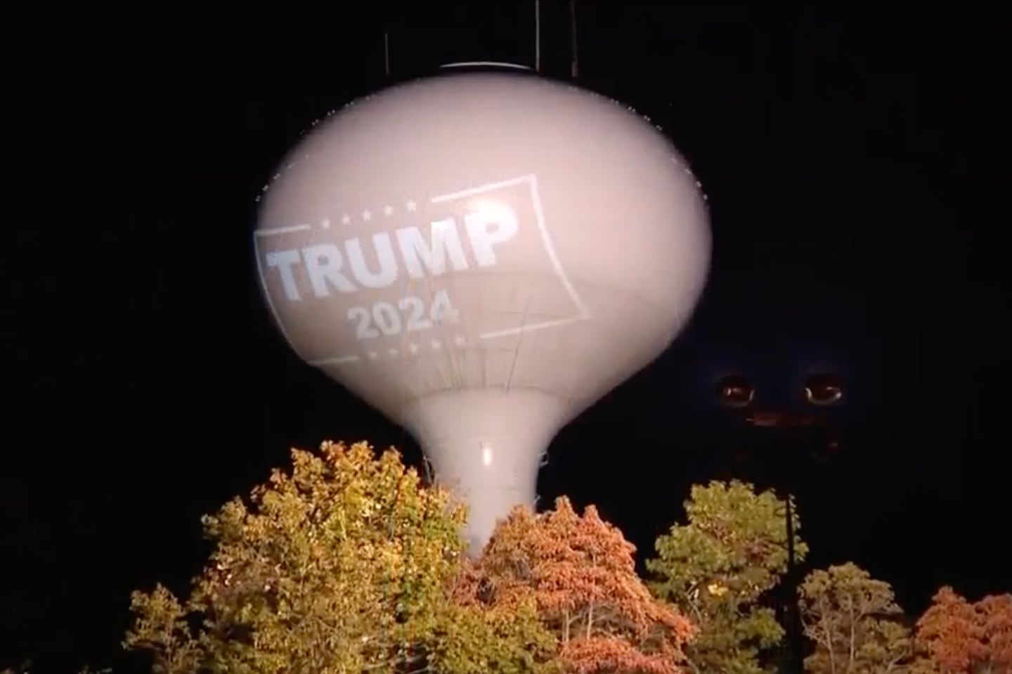 A Trump 2024 logo is projected onto a water tower in Hanson.