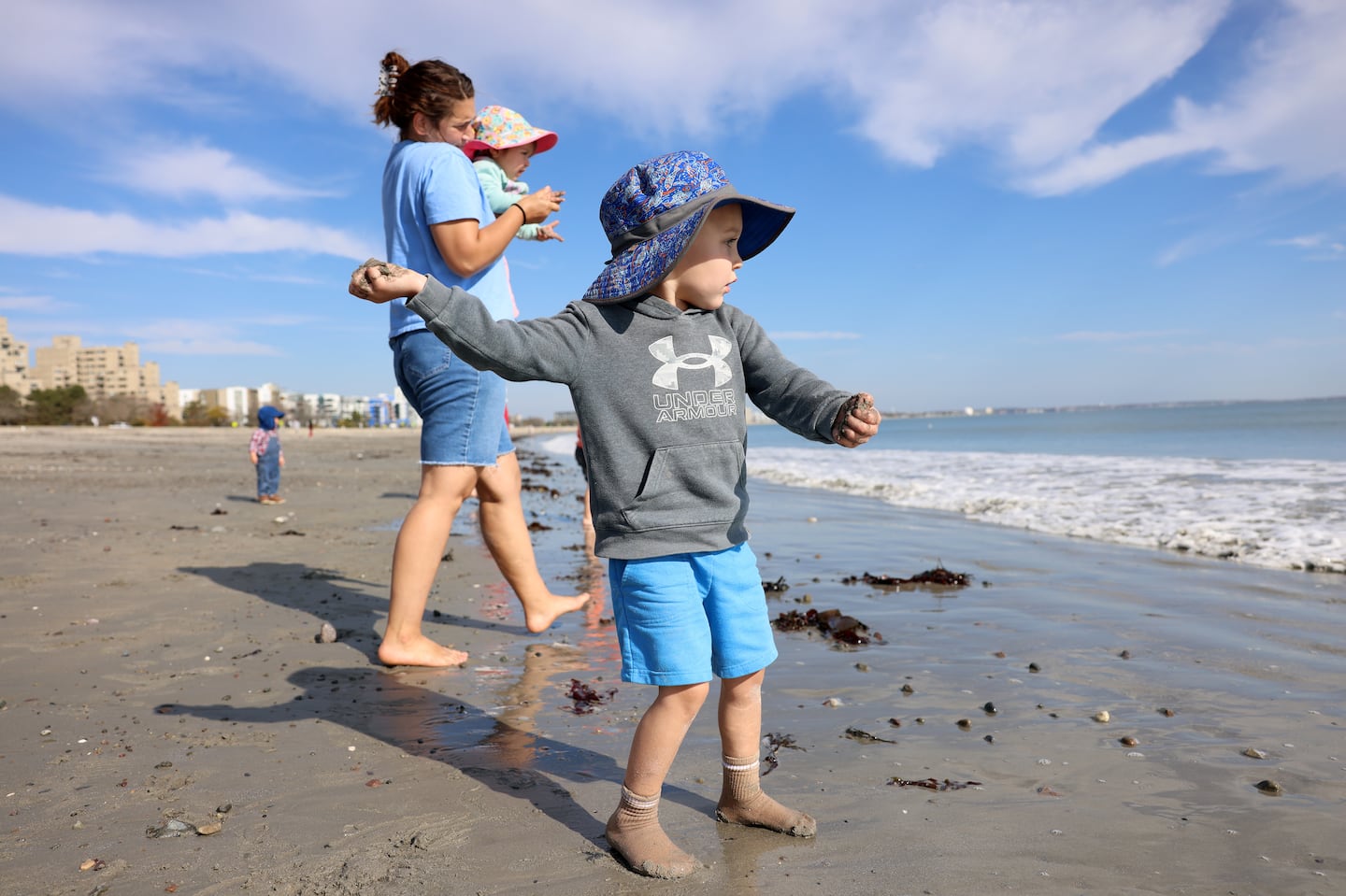 Three-year-old Rocco prepares to launch a mudpie into the sea at Revere Beach on a warm October day Monday.