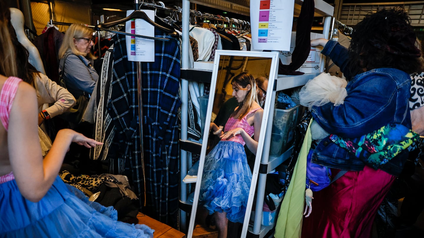 People tried on clothes and costumes at the American Repertory Theater's costume sale Friday. The sale continues Saturday and next weekend.