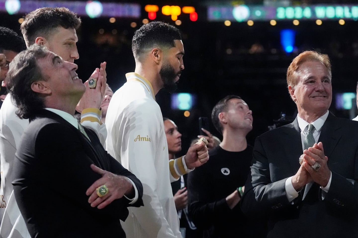 Celtics owners Wyc Grousbeck (left) and Steve Pagliuca (right) looked on as the championship banner was raised at TD Garden Tuesday night. Celtics forward Jayson Tatum (center) checked out his new ring.