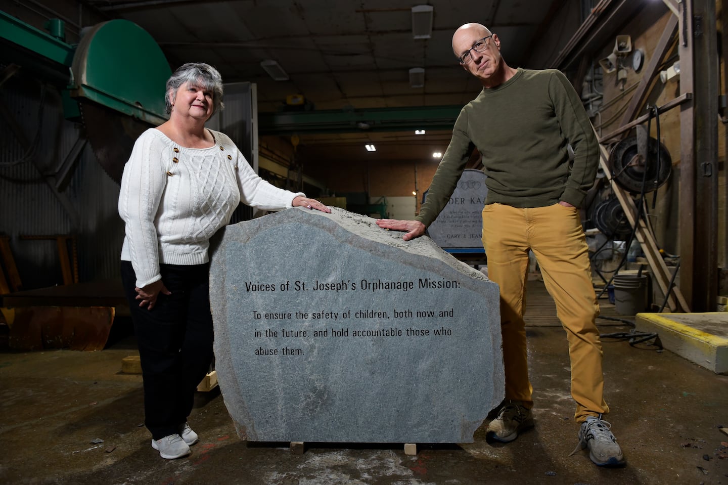 Brenda Hannon, a survivor of abuse at St. Joseph's Orphanage in Vermont, and Marc Wennberg, the facilitator of the restorative justice inquiry, stood with an engraved stone that will appear in a memorial park for the children who suffered at the orphanage.