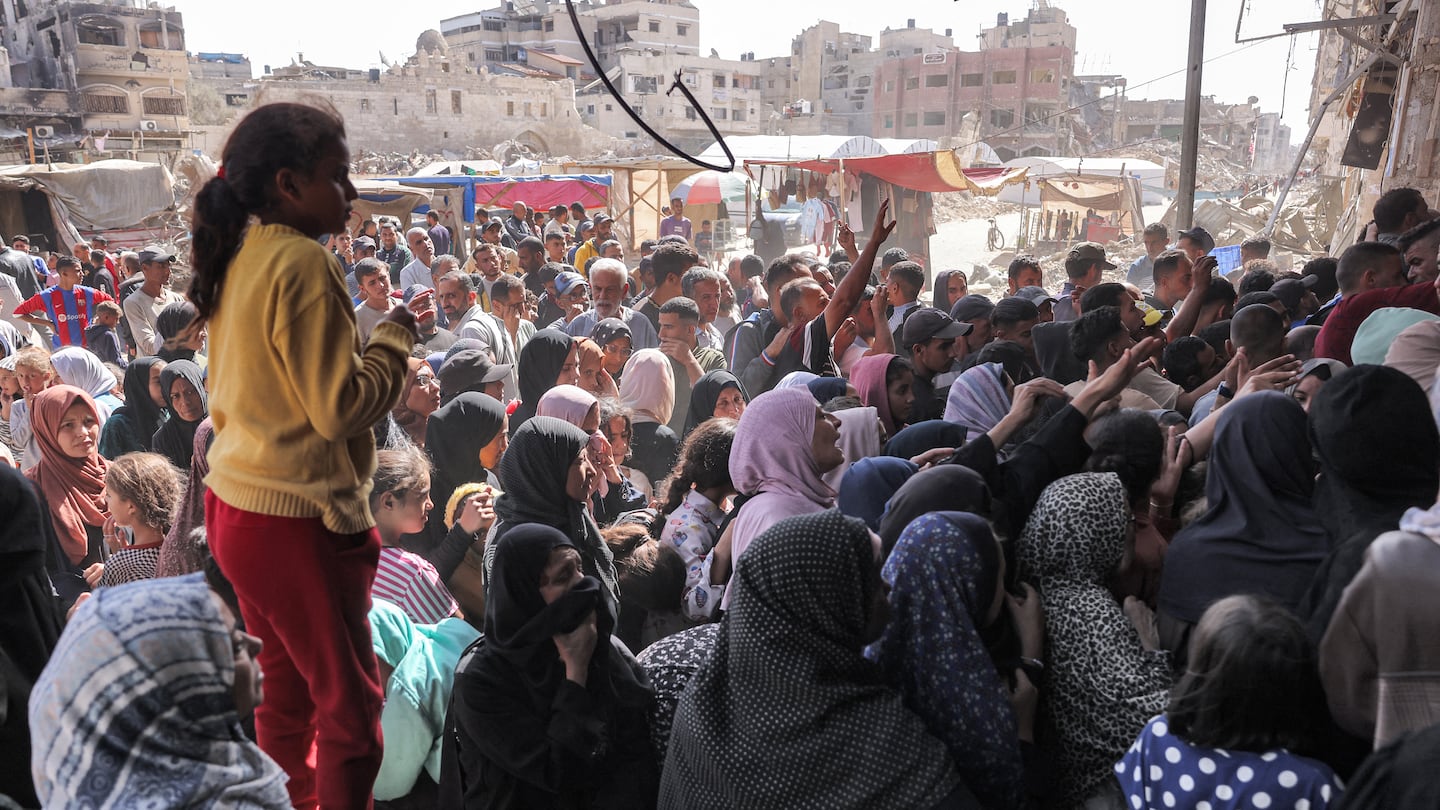 A girl looked on as people queue for bread outside a bakery in Khan Yunis in the southern Gaza Strip on Wednesday amid the ongoing war in the Palestinian territory between Israel and Hamas.