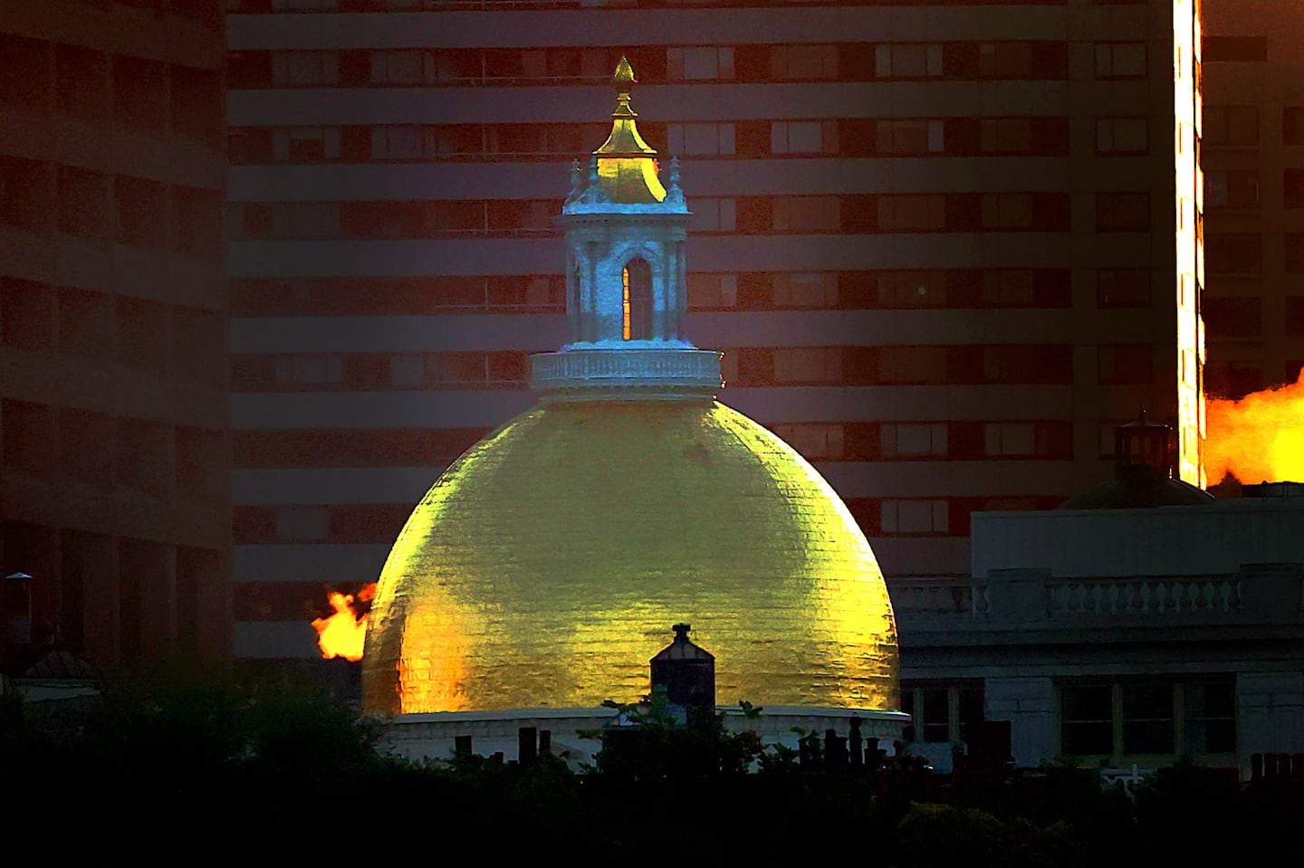 The Massachusetts State House and steam backlit by the morning sunrise on Oct. 4, 2024.