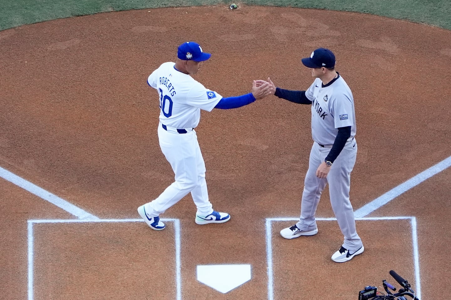 Dodgers manager Dave Roberts (left) and Aaron Boone (right) will forever be linked to two of the biggest moments in Red Sox postseason history.