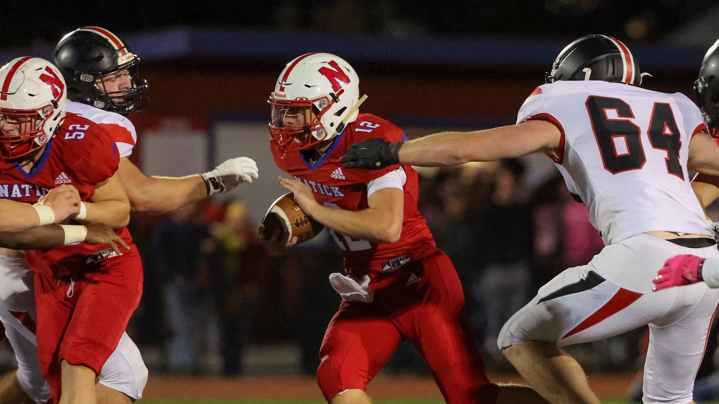 Natick High quarterback Jessse Gagliardi (12) runs behind blocker Jonathan Chase (52) past Wellesley's Jason Stephens (64) in a 27-19 Bay State Conference win for the Redhawks.